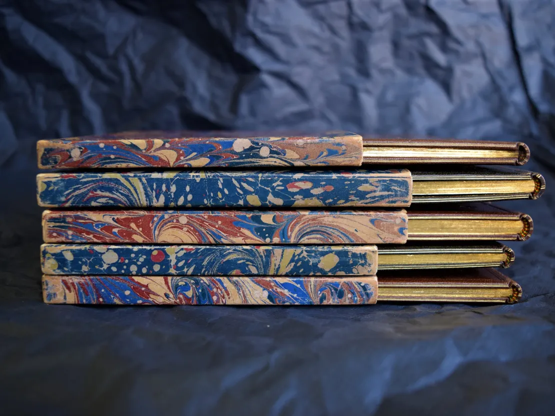 Vijf libretti in foedraal van gemarmerd papier.